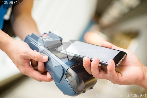 Image of Customer using cellphone for pay by NFC technology