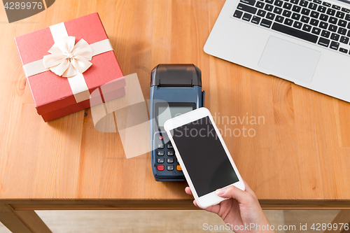 Image of Pay with cellphone on POS machine for buying gift