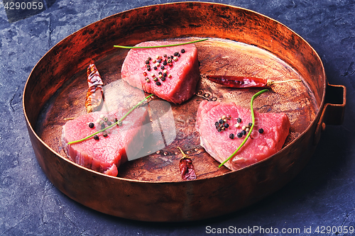 Image of raw steak in frying pan