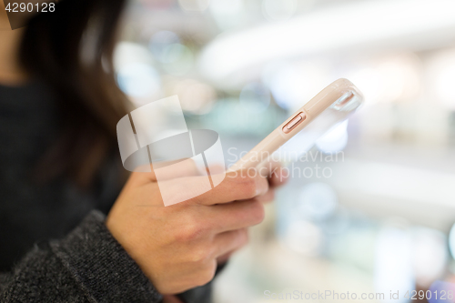 Image of Woman using mobile phone in shopping mall