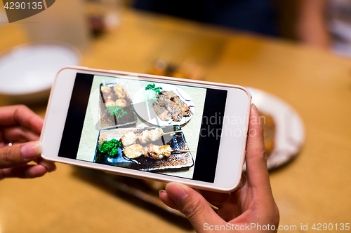 Image of Taking photo by mobile phone before having dinner