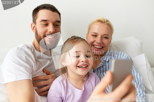 Image of happy family taking selfie by smartphone at home
