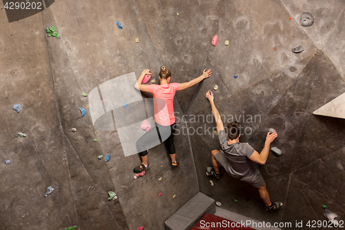 Image of man and woman exercising at indoor climbing gym