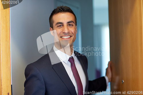 Image of businessman at hotel room or office door