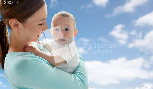 Image of happy young mother with little baby over blue sky