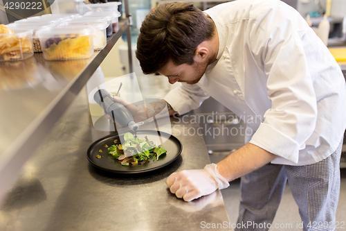 Image of male chef cooking food at restaurant kitchen