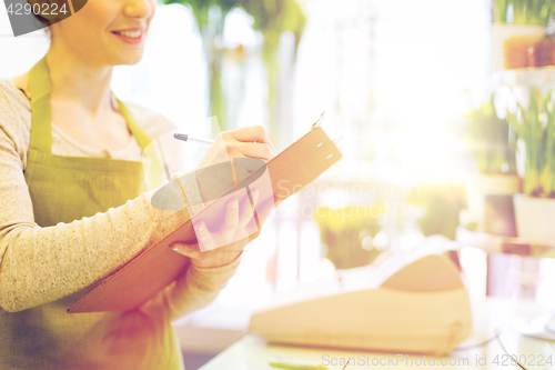 Image of close up of woman with clipboard at flower shop