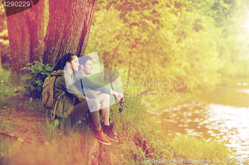 Image of smiling couple with backpacks in nature