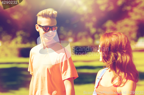 Image of happy teenage couple walking at summer park