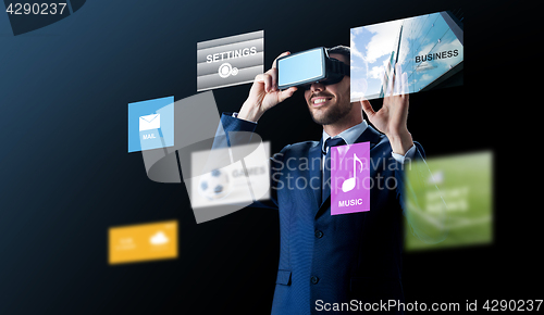 Image of businessman in virtual reality headset over black