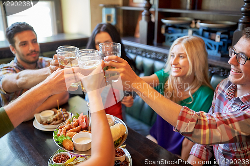 Image of happy friends drinking beer at bar or pub