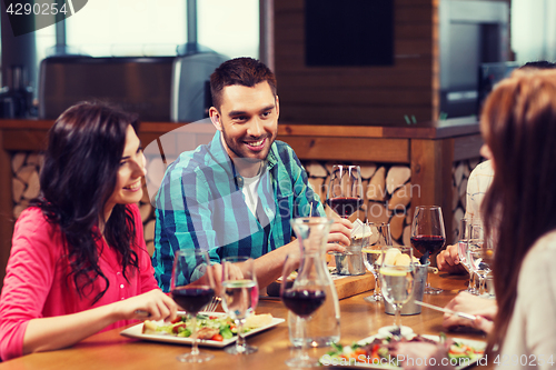 Image of friends dining and drinking wine at restaurant