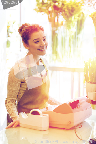 Image of smiling florist woman at flower shop cashbox