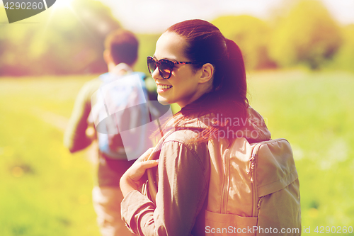 Image of happy couple with backpacks hiking outdoors