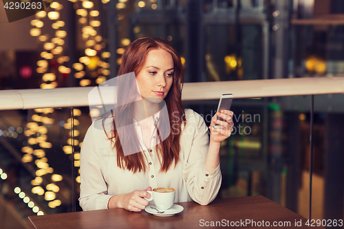 Image of woman with smartphone and coffee at restaurant