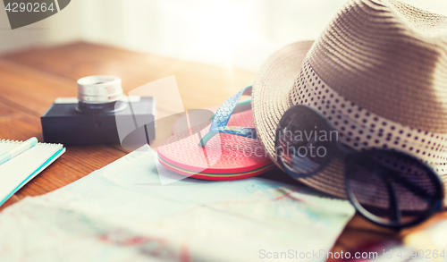 Image of close up of travel map, flip-flops, hat and camera