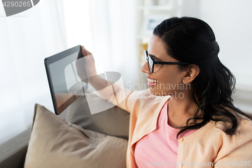 Image of happy indian woman with tablet pc at home