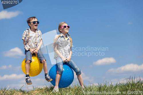 Image of Brother and sister playing on the field at the day time.