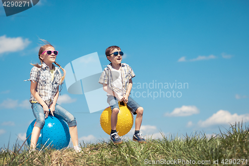 Image of Brother and sister playing on the field at the day time.