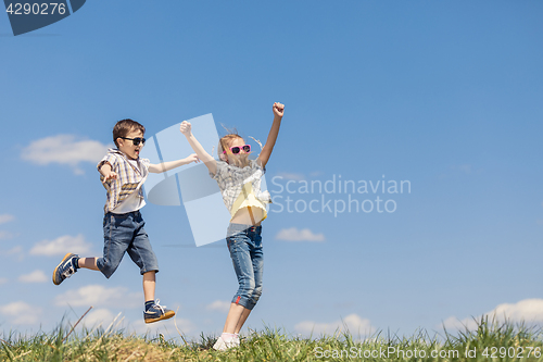 Image of Brother and sister playing on the field at the day time.