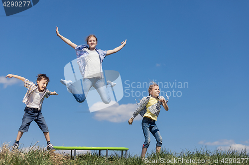 Image of Brother and sisters playing on the field at the day time.