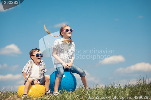 Image of Brother and sister playing on the field at the day time.