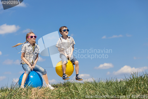 Image of Brother and sister playing on the field at the day time.