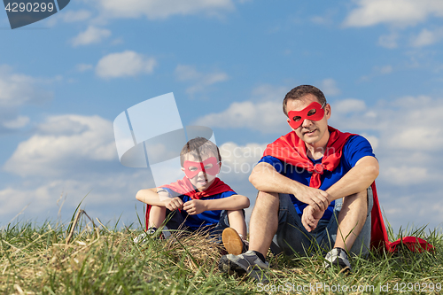 Image of Father and son playing superhero at the day time.