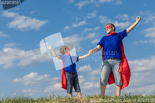 Image of Father and son playing superhero at the day time. 