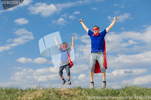 Image of Father and son playing superhero at the day time.