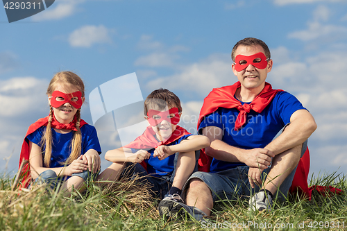 Image of Father and children playing superhero at the day time.