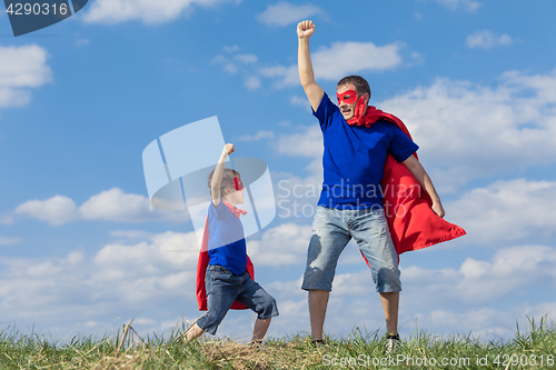 Image of Father and son playing superhero at the day time.