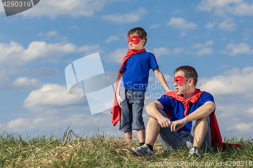 Image of Father and son playing superhero at the day time.