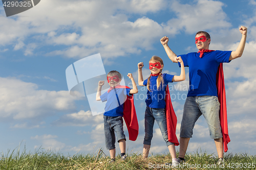 Image of Father and children playing superhero at the day time.