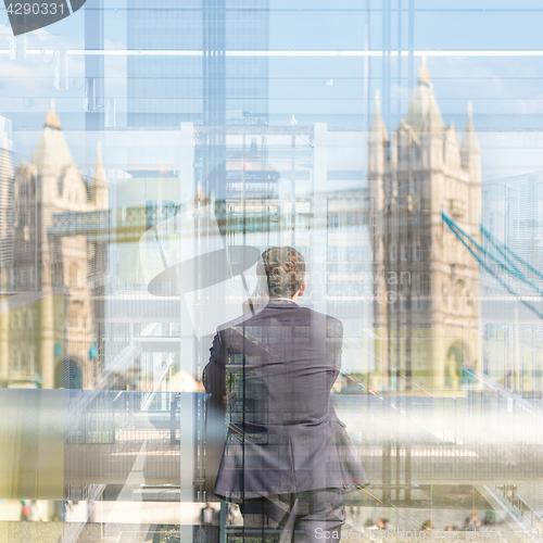 Image of British businessman talking on mobile phone in London city, UK.