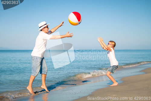 Image of Father and daughter playing on the beach at the day time.