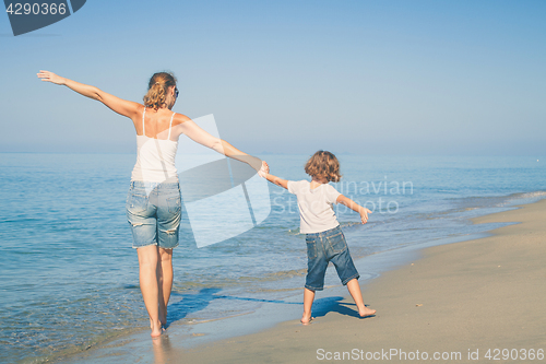 Image of Mother and son playing on the beach at the day time.