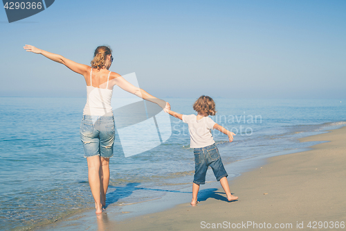 Image of Mother and son playing on the beach at the day time.