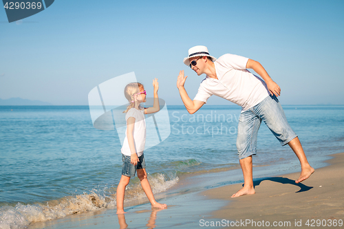 Image of Father and daughter playing on the beach at the day time.