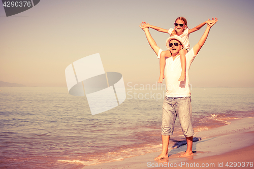 Image of Father and daughter playing on the beach at the day time.