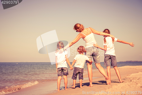 Image of Mother and  children playing on the beach.