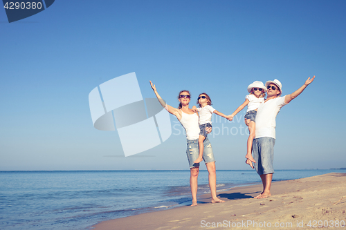 Image of Happy family walking on the beach at the day time.