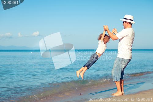 Image of Father and son playing on the beach at the day time.