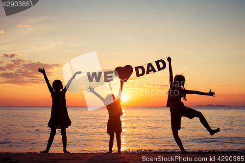 Image of Happy children playing on the beach at the sunset time.