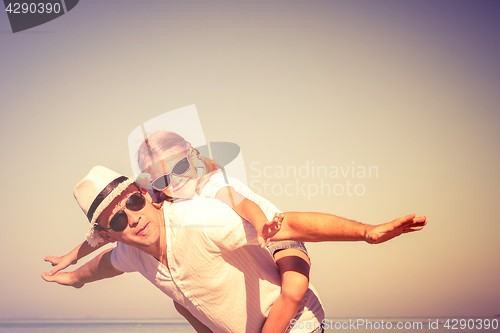 Image of Father and daughter playing on the beach at the day time.