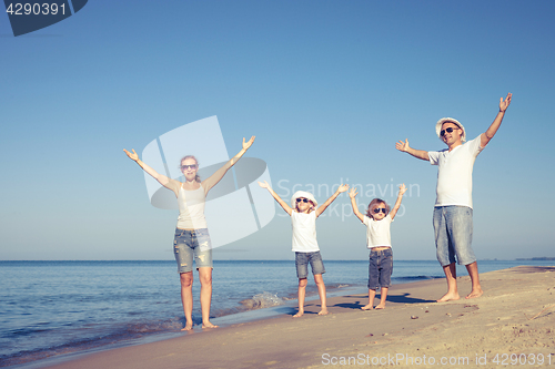 Image of Happy family walking on the beach at the day time.