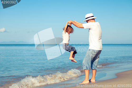 Image of Father and son playing on the beach at the day time.