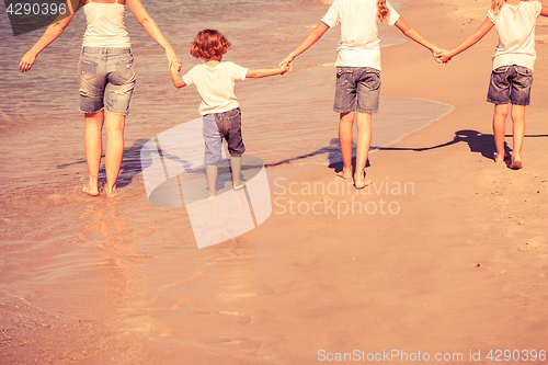 Image of Mother and  children playing on the beach.