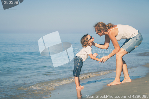 Image of Mother and son playing on the beach at the day time.