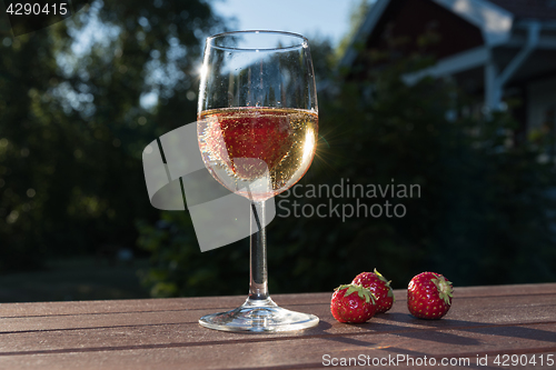 Image of Sparkling wine and strawberries in a garden